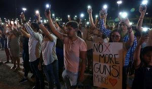 Demonstrators against gun violence carry No More Guns poster