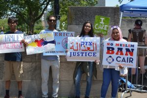 Volunteers holding signs for justice and against Muslim ban