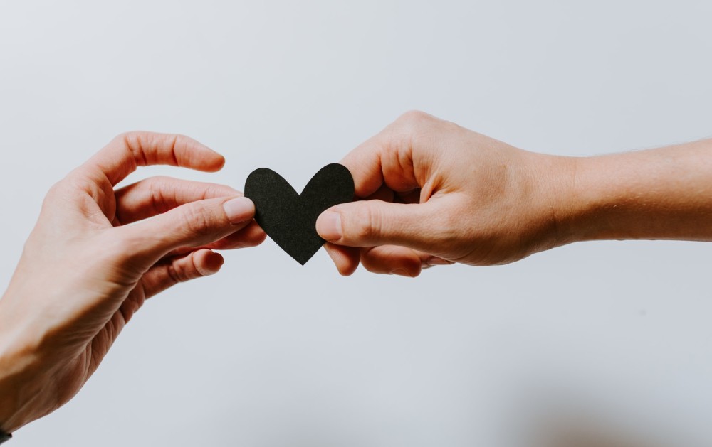 Hands holding a heart-shaped paper. Photo by Kelly Sikkema on Unsplash